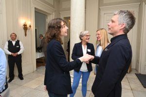 Kai Gosslar begrüßt Anna Tötter vom Diakonischen Werk Hamburg, im Hintergrund Natja Berg mit Claudia Langholz (ebenfalls DW)